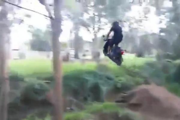 Australian-jumps-creek-on-small-engine-motor-scooter
